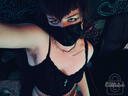 Ryder taking a downward selfie in a black camisole and medical mask